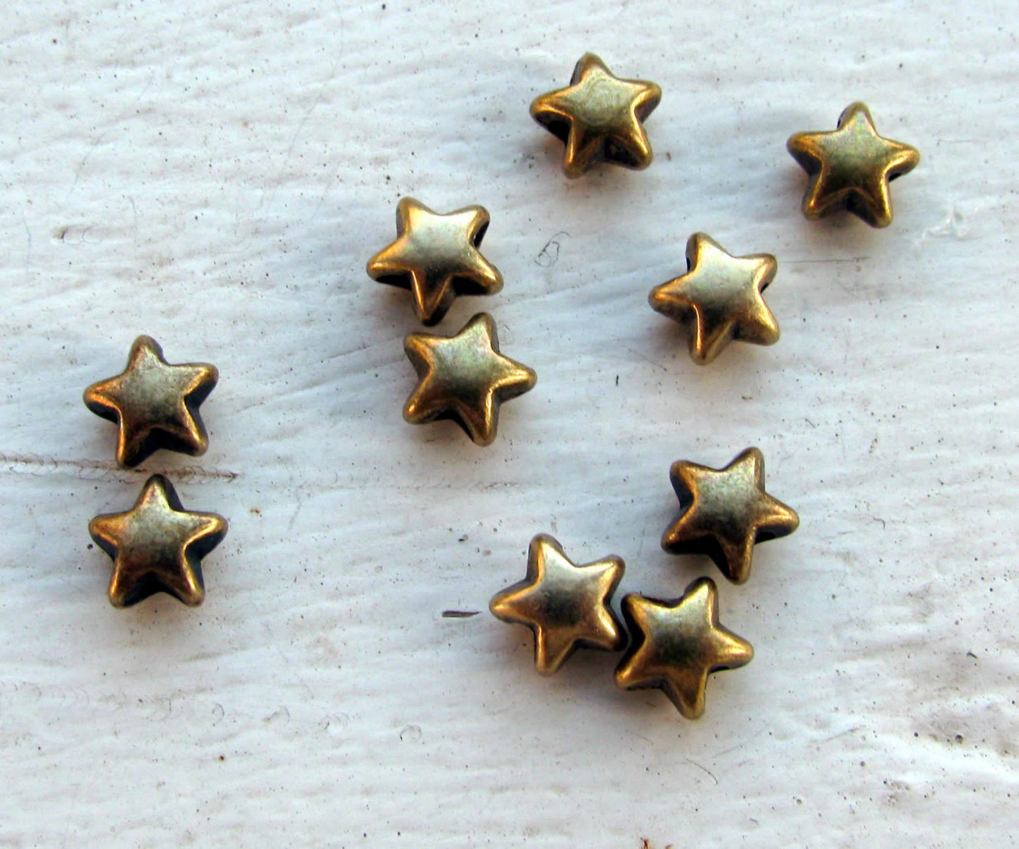 Mellandel bronsfärgad - Liten stjärna, 6mm, 10-  pack